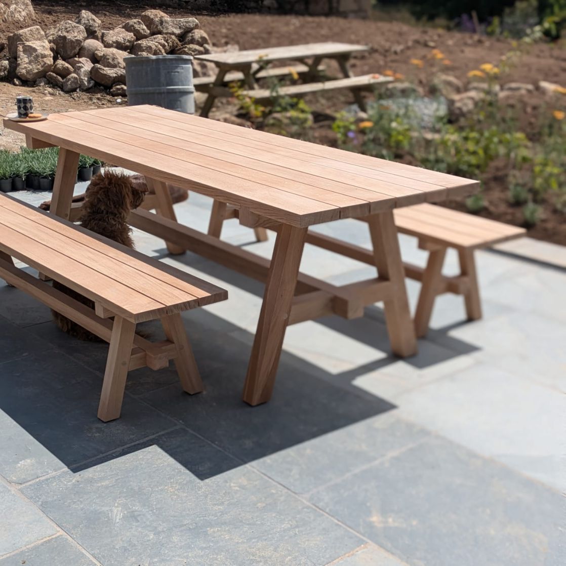 Prenn table and benches on patio for outdoor dining made using traditional joinery