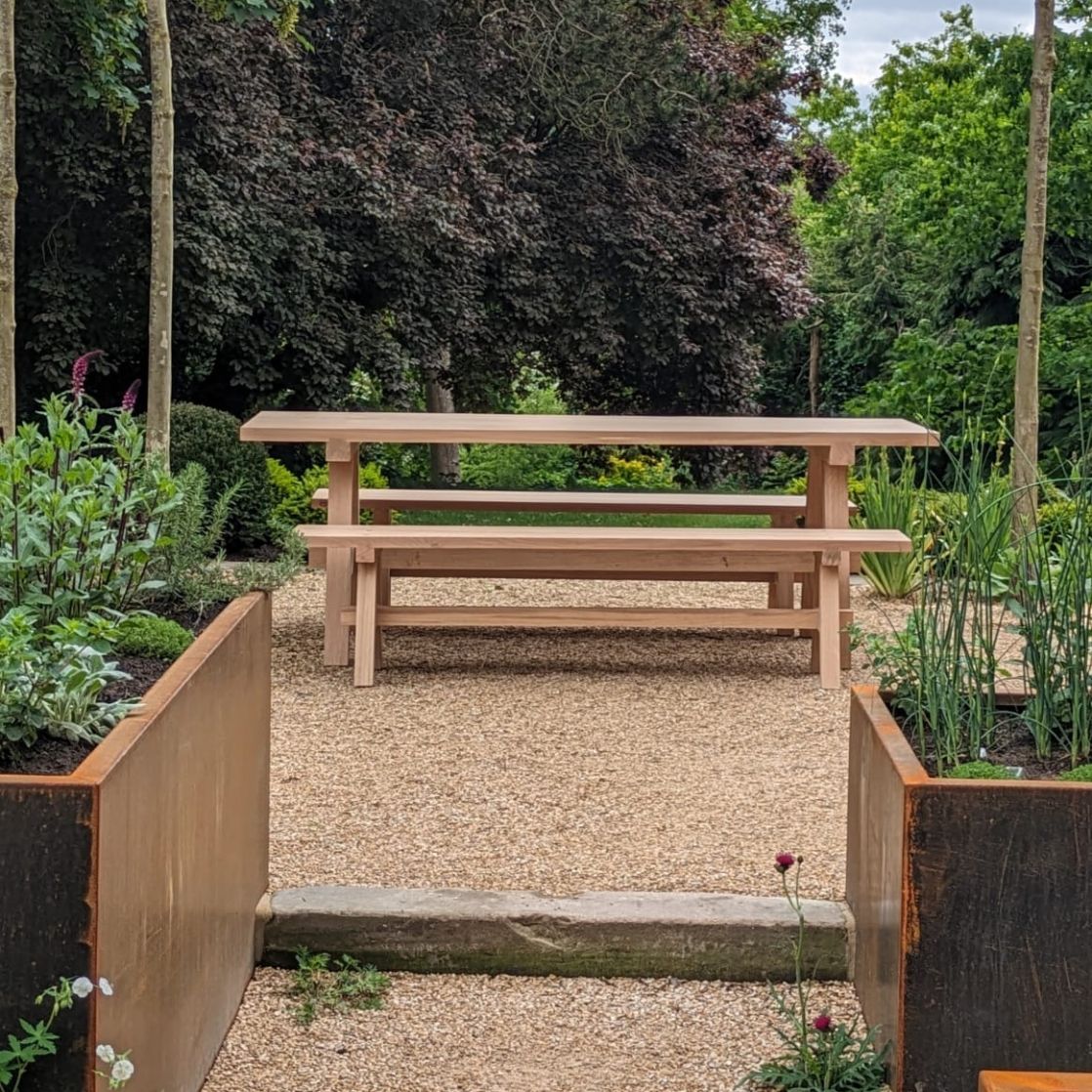 Outdoor dining table and bench - elegant stylish lines, contemporary style in landscaped garden